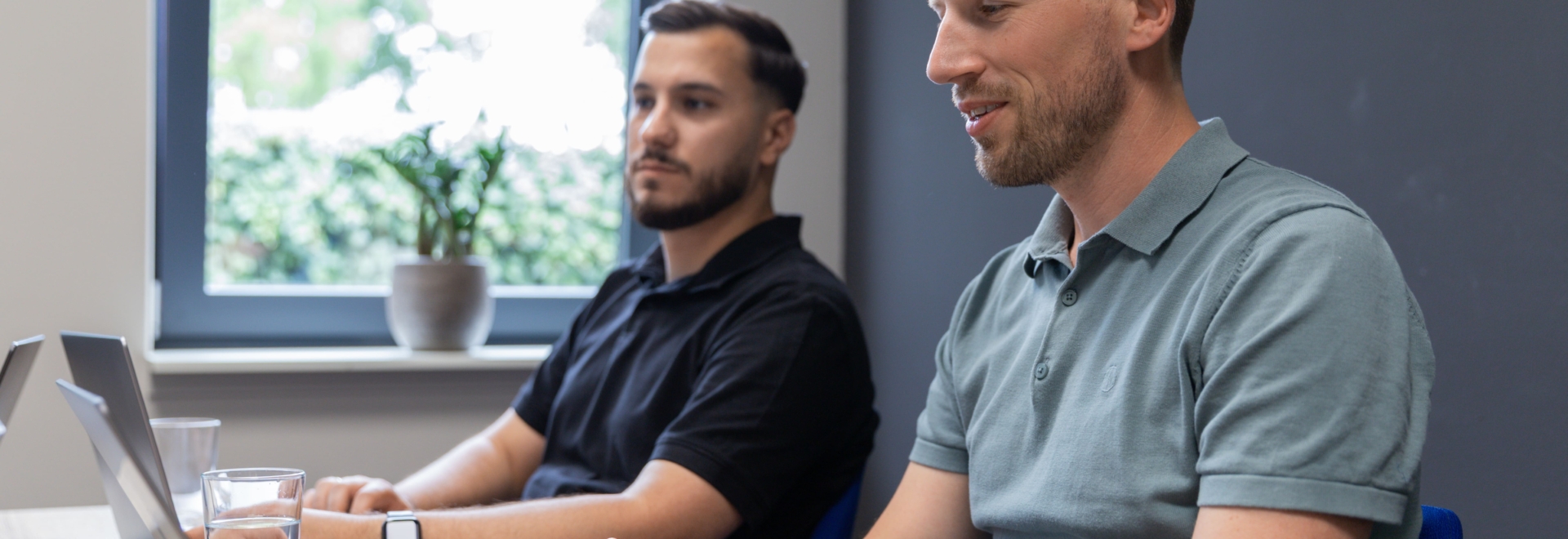 Online marketeers Maurice en Talha zitten naast elkaar aan een tafel om te werken