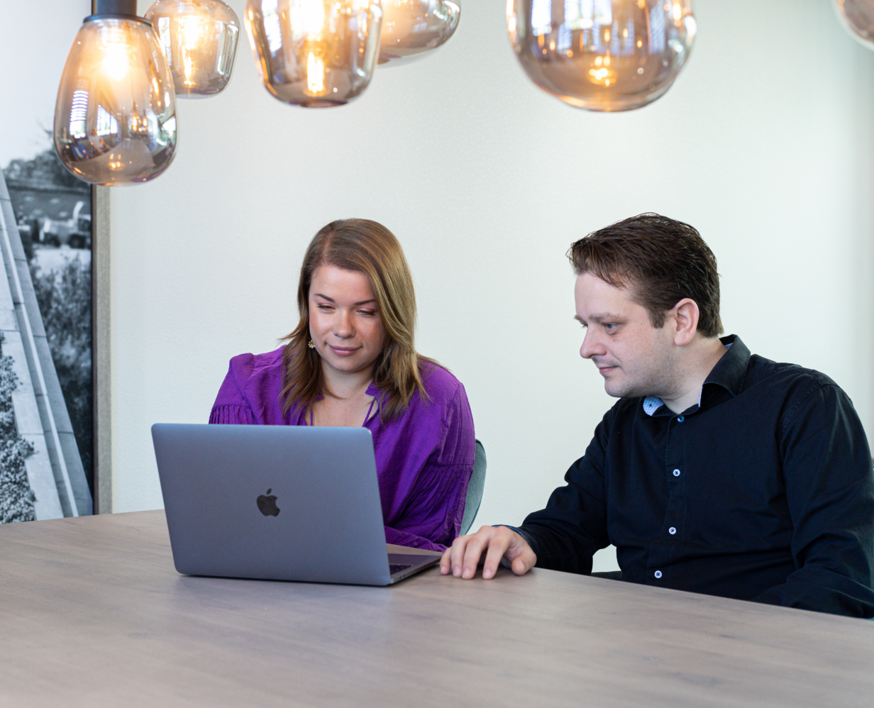 Data & AI specialist Arthur kijkt mee op de laptop bij Anna, content marketeer