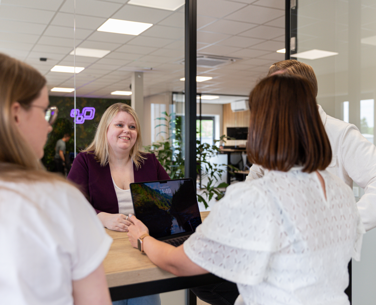 Booosters-collega Dafne op het Booosters-kantoor in gesprek met collega's