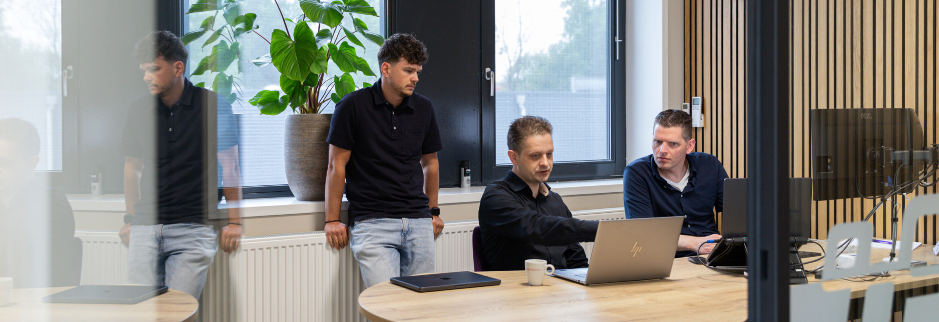 Jan, Arthur en Calvin zitten in een kantoor te overleggen
