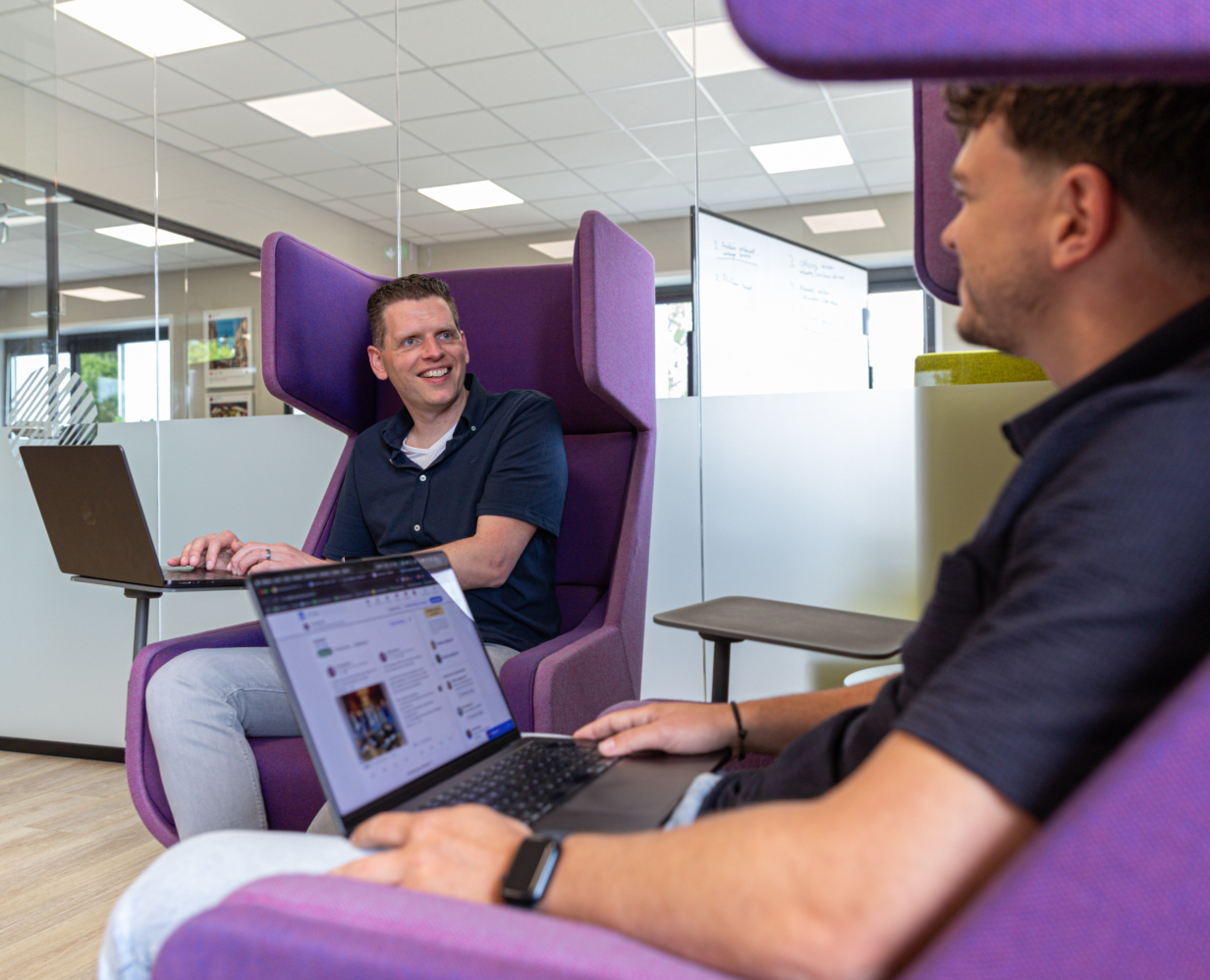 Online marketing adviseur Jan en digital strateeg Calvin overleggen in 2 grote paarse stoelen