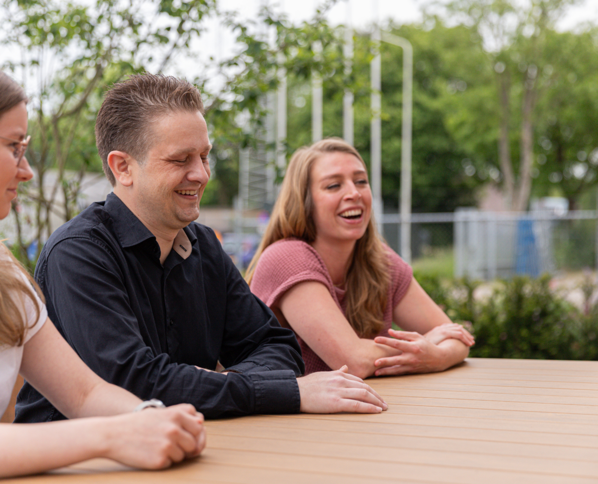 Jamie, Arthus en Kim zitten buiten aan een picknick tafel